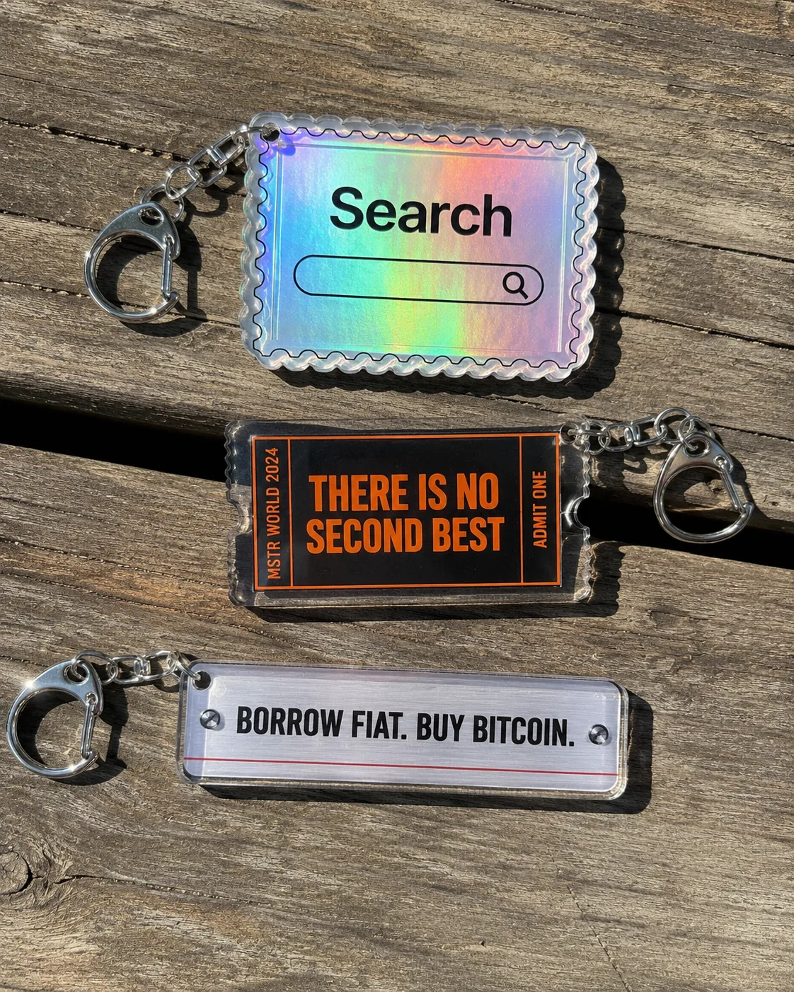 A collection of tech culture keychains on a wooden surface