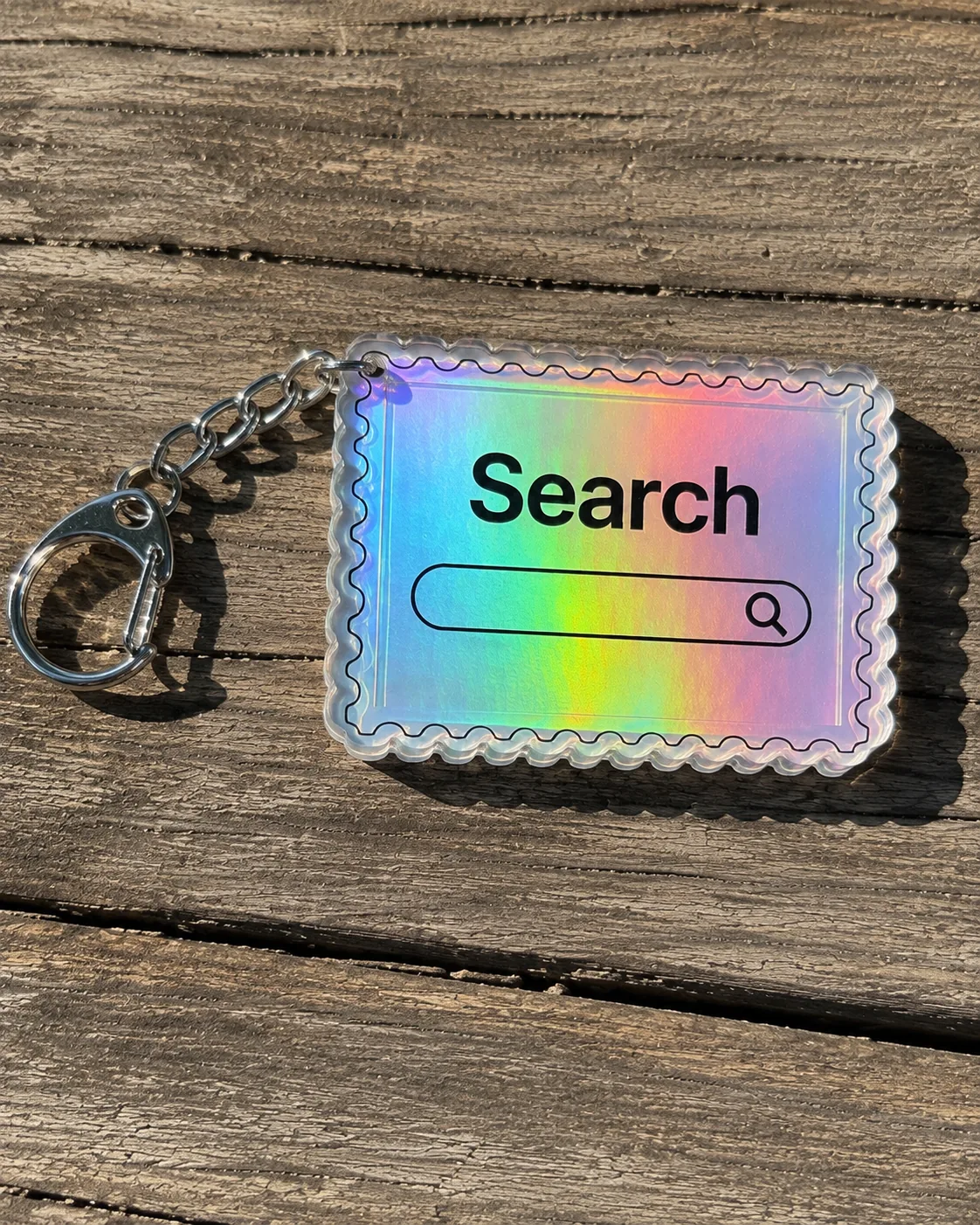 Holographic Search keychain on a wooden surface